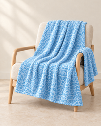 Sky Blue patterned throw draped over an oatmeal linen and pale oak chair