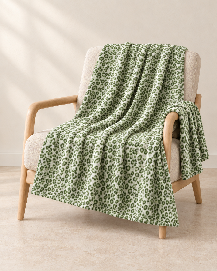Sage Green patterned throw draped over an oatmeal linen and pale oak chair