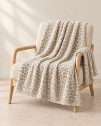 Cream patterned throw draped over an oatmeal linen and pale oak chair