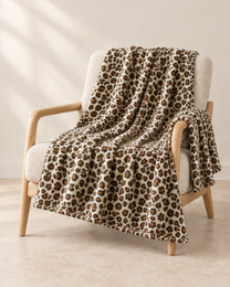 Ivory Leopard patterned throw draped over an oatmeal linen and pale oak chair