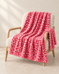 Coral Pink patterned throw draped over an oatmeal linen and pale oak chair