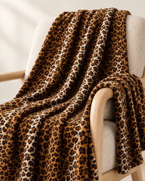 Close view of the Classic Brown leopard throw draped over a pale oak chair arm