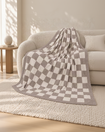 Gray and ivory checkerboard throw on an oatmeal sofa