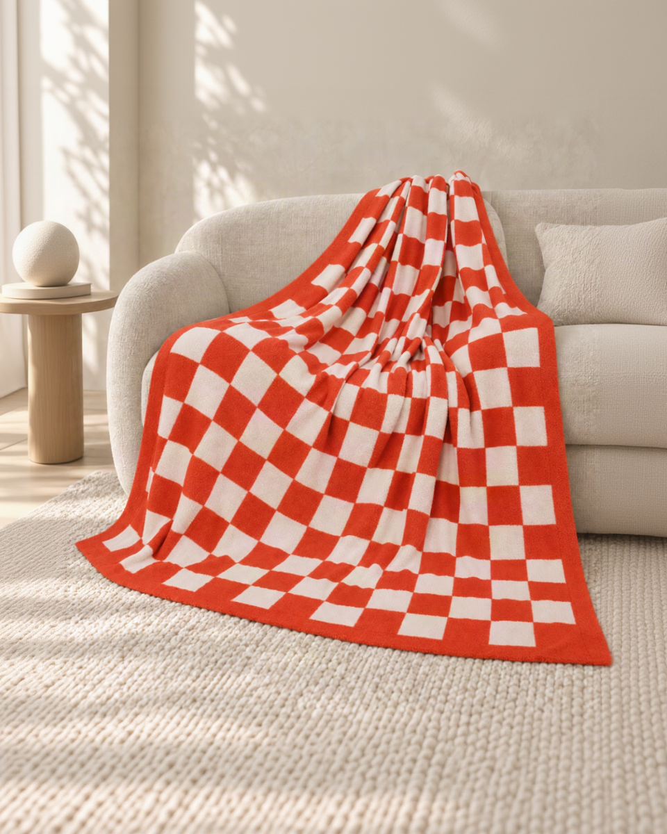 Orange and ivory checkerboard throw on an oatmeal sofa