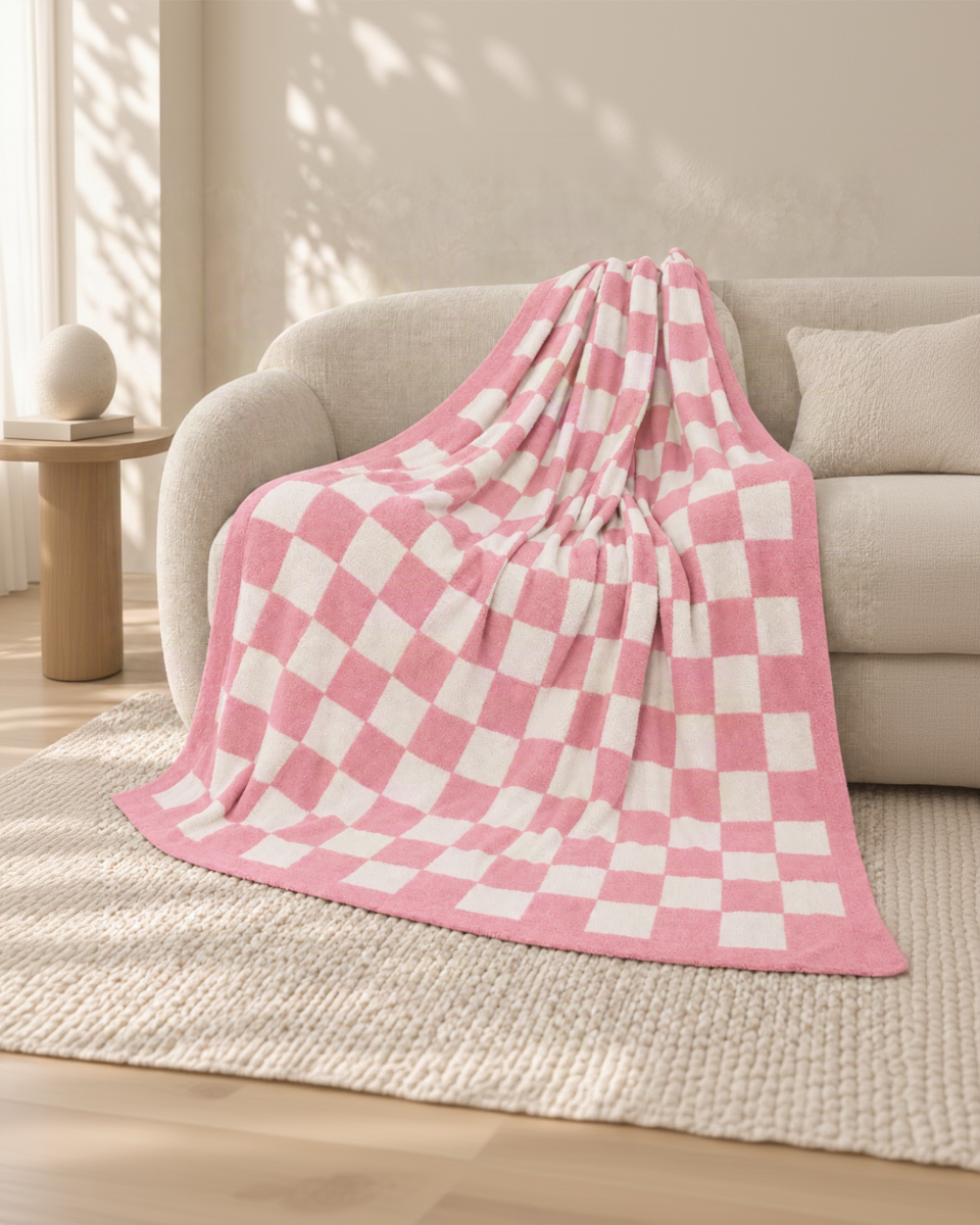 Pink and ivory checkerboard throw on an oatmeal sofa