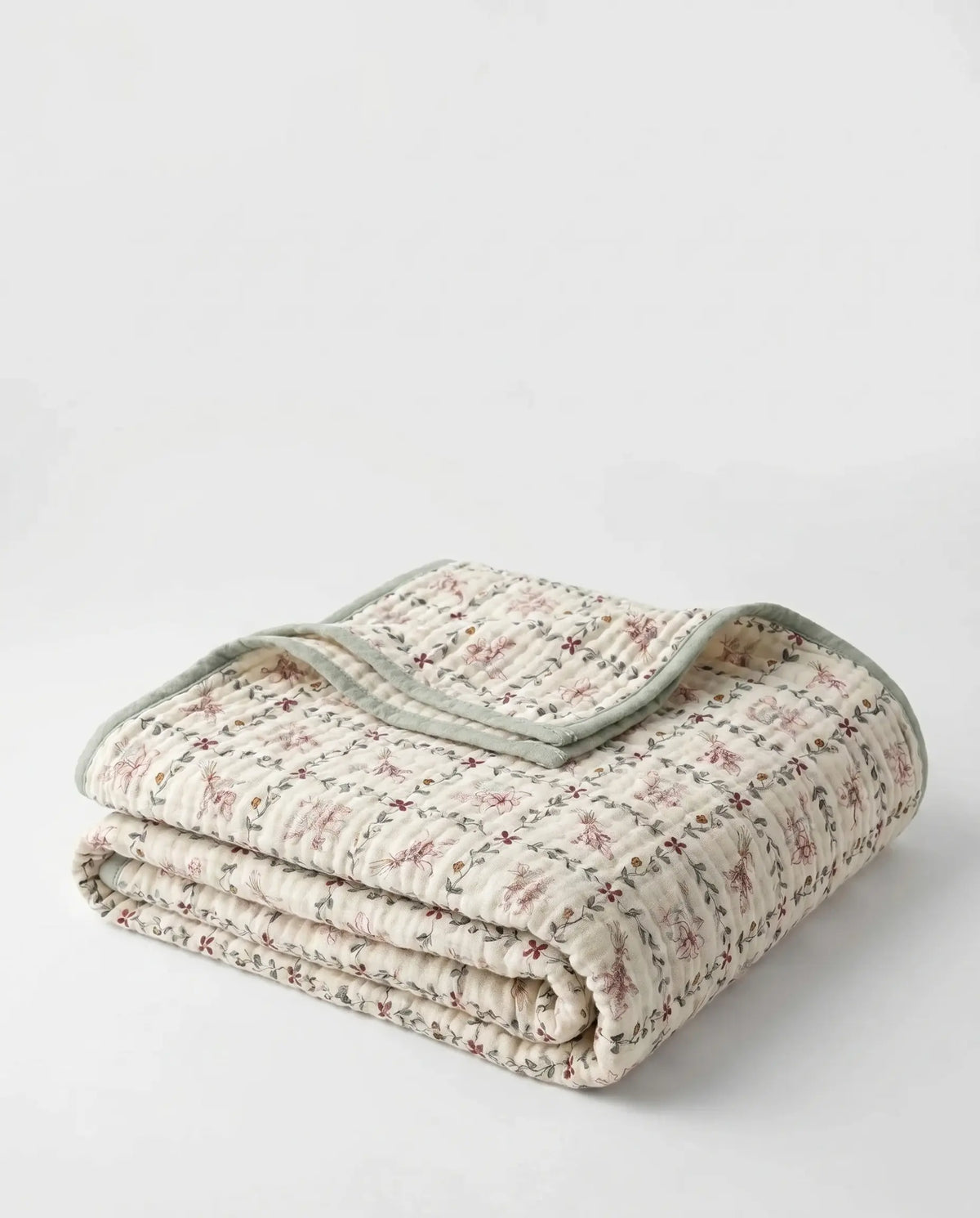 Magnolia print muslin blanket on a bed