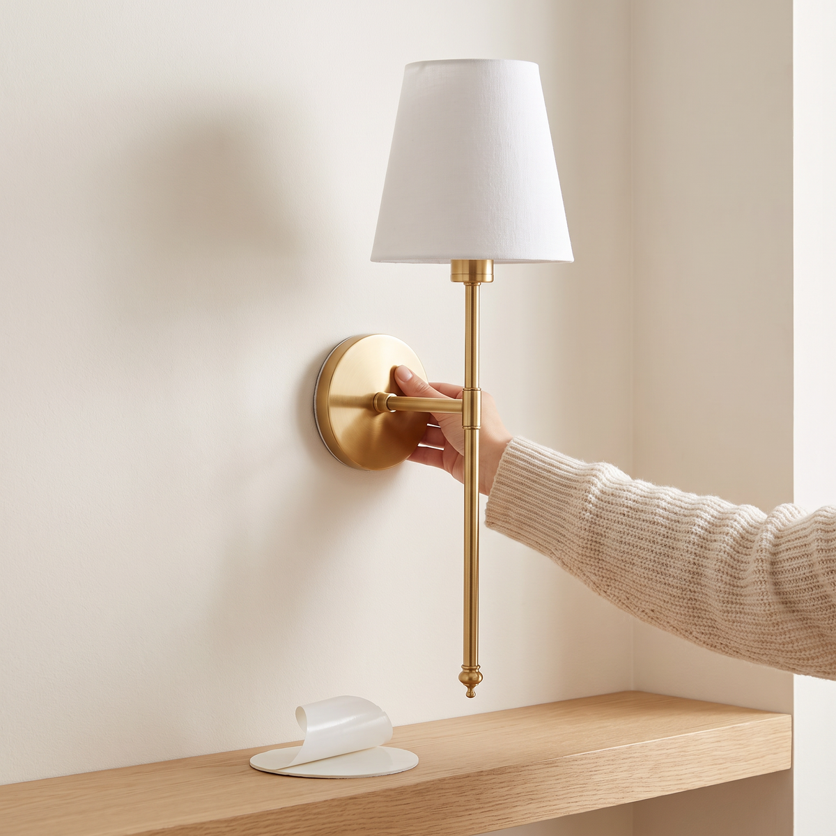 Peel-and-stick installation of the wireless wall sconce, no drilling