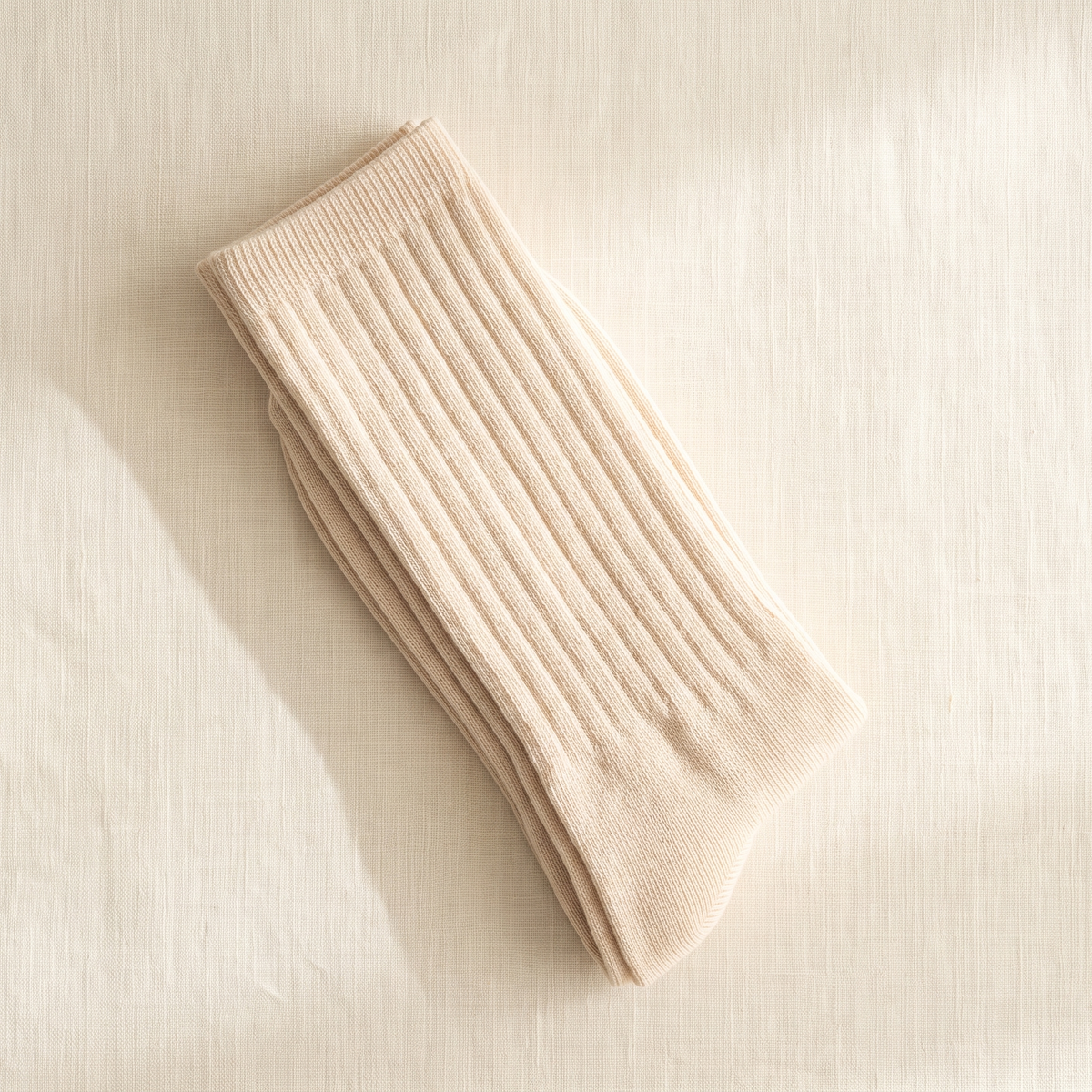 Cream ribbed lounge socks folded on ivory linen; colour reference for a pack of five matching pairs.