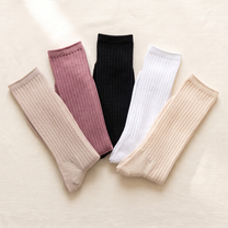 Mixed five-pair pack: one pair each in White, Beige, Dusty Rose, Black and Cream. Five colour samples arranged on ivory linen.